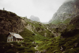 Berghütte in den Alpen mit Nebel im Gebirge. Weil wir die Natur und die Alpen lieben und schützen.